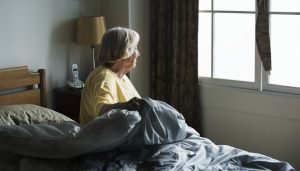 Senior woman sitting in a bedroom
